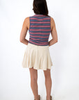 Back view of woman wearing striped sleeveless top and cream skort