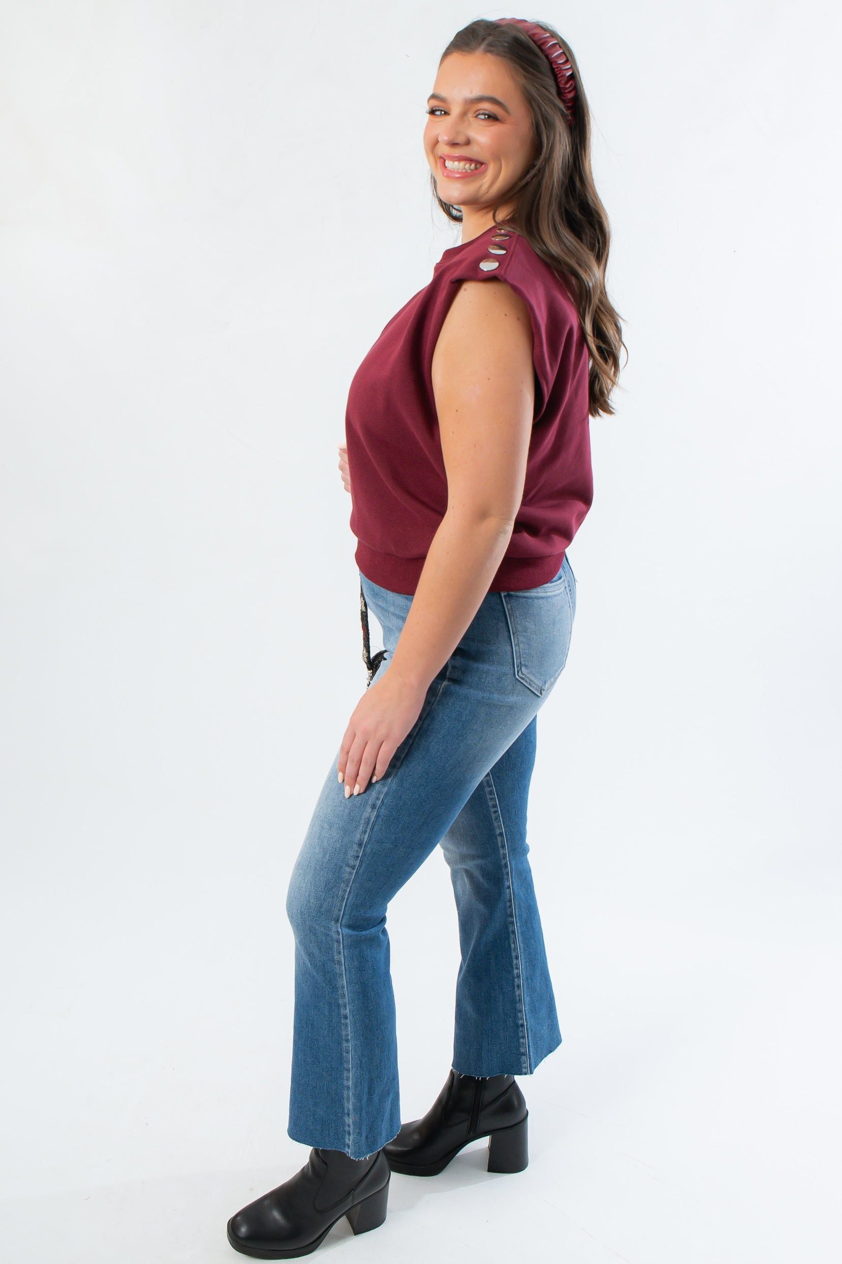 Side view of THML Burgundy Studded Sleeveless Top highlighting structured shoulders and metallic studs.