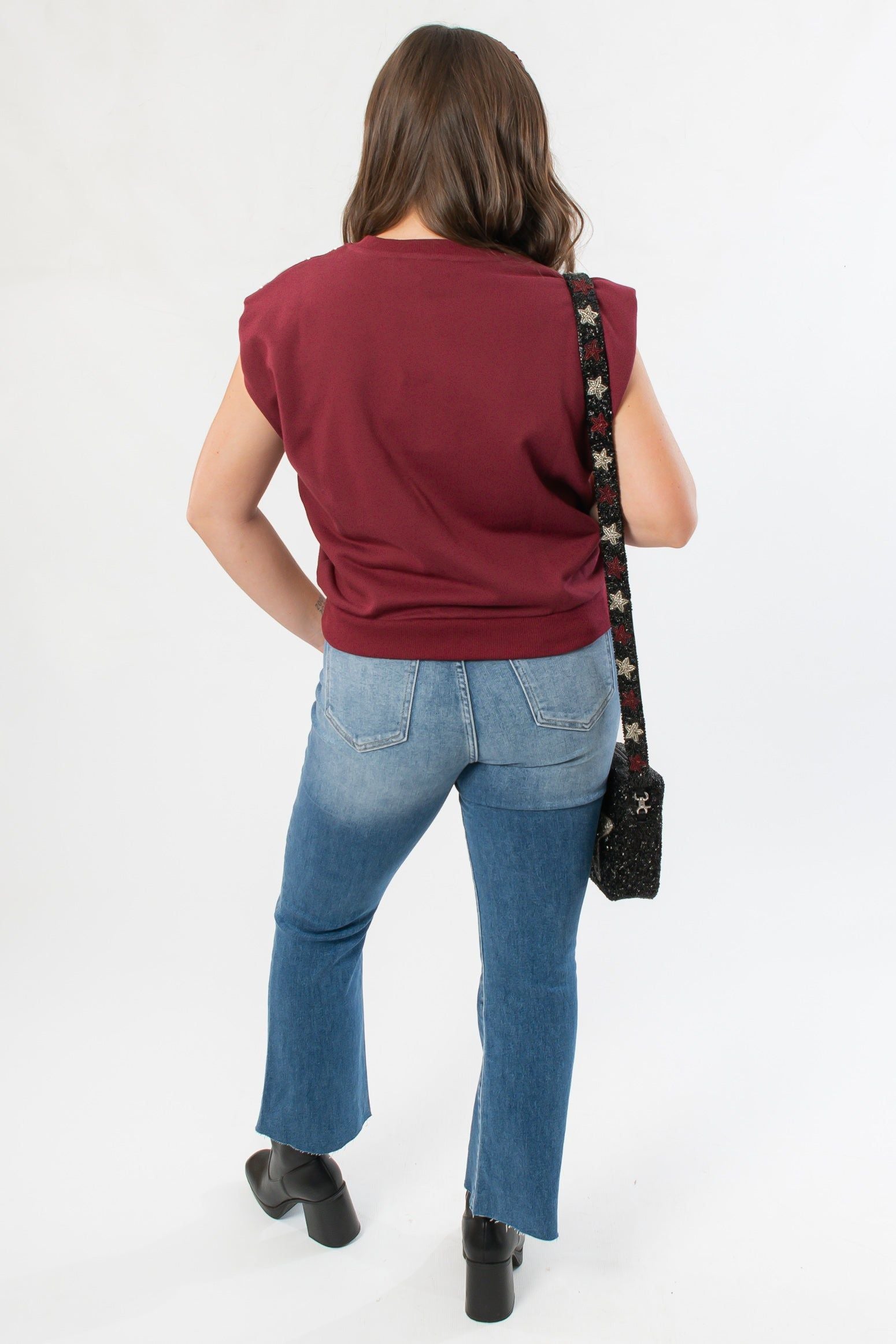 Back view of THML Burgundy Studded Sleeveless Top paired with denim, showcasing relaxed fit and fall-ready style.
