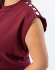 Close-up of THML Burgundy Studded Sleeveless Top showing silver stud details on thick sweatshirt fabric.