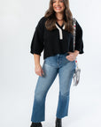 Black Contrast Collared V-Neck Sweater by Angie paired with flare jeans and boots, perfect for gameday or casual fall looks.
