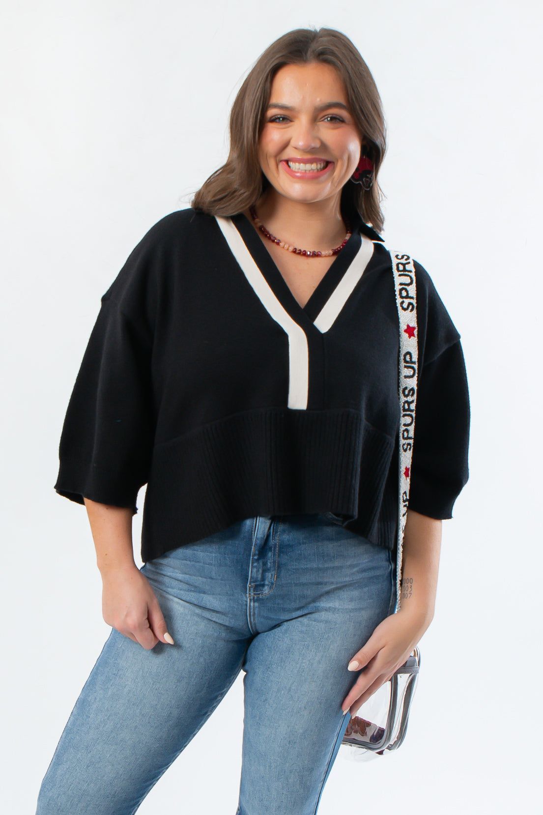 Angie V-Neck Sweater - Black Polo features a cropped fit with contrast white collar and V-neckline, styled with light-wash jeans for fall fashion.