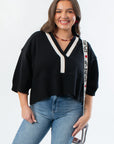 Angie V-Neck Sweater - Black Polo features a cropped fit with contrast white collar and V-neckline, styled with light-wash jeans for fall fashion.