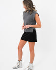 Side view of Rowan Grey Mockneck Sweater Tank styled with black skirt, showing the relaxed fit and ribbed hem details.