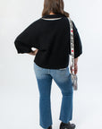 Back view of Angie Contrast Collared Crop Sweater in black, highlighting ribbed hem and oversized sleeves for a cozy fall outfit.