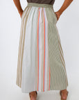 full-length view of woman in striped midi skirt with beige platform sandals