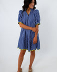 Back view of woman in blue striped dress with yellow trim, showing hairstyle and dress details
