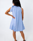 Back view of woman in blue pinstripe dress with bow tie neck