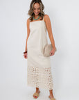 Side view of Seagarden floral eyelet hem midi dress in ecru with model holding clutch