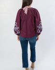 Back view of Wine Multi Long Sleeve Embroidered Blouse with gathered shoulders and flowy silhouette, paired with cropped jeans and boots.