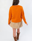 Back view of Game Day Orange Knit Sweater showing relaxed fit and ribbed hem, styled for casual fall layering.