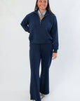 Model wearing Spanx AirEssentials Timeless Navy Wide Leg Pant and matching top, showcasing breathable, stretchy lounge set.