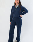 Spanx AirEssentials Half Zip in navy styled with matching pants, offering a chic and comfortable lounge set for versatile wear.