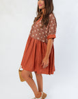 Side view of Chateau Chic Rust Embroidered Babydoll Dress showing relaxed fit and short cuffed sleeves for fall styling.
