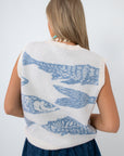 side view of woman in sleeveless knit fish sweater with blue fish pattern