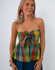 Back view of woman in plaid strapless top with pink earrings