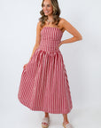 Woman wearing a red and white striped dress on a white background