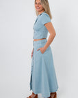 Back view of light blue denim cropped top and maxi skirt set with button details, casual spring outfit