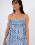 Close-up of light blue polka dot smocked mini dress with adjustable straps and gathered bodice