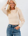 Park Avenue Cream Tie Neck Sweater with elegant bow detail and ribbed knit texture, styled with long sleeves for a chic fall look.