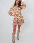 Clyvedon Cream Floral Patterned Mini Dress with waist tie and colorful border hem, styled with beige cowboy boots
