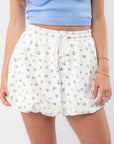 Close-up of Bella Knit Bubble Hem Skirt in blue ditsy floral print with drawstring waist and bubble hem, perfect for spring casual wear.