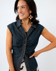 Woman wearing a denim vest styled for a summer country concert on a white background