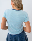 Woman wearing a light blue t-shirt and dark blue skirt on a white background