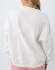 Person wearing a white sweatshirt and pink pants on a white background