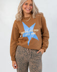 Grateful for Everything Graphic Star Sweatshirt in brown with blue star and white text, styled with leopard print pants. Cozy fall knit top.