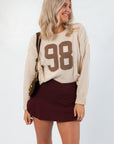 Model wearing Dark Cherry Yoga Skort with crossover detail and soft stretch fabric, styled for a cozy and sporty fall outfit.