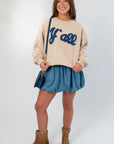 Front view of Denim Bubble Skort - Mini Skort paired with casual sweatshirt and boots, highlighting its high waist and bubble hem.