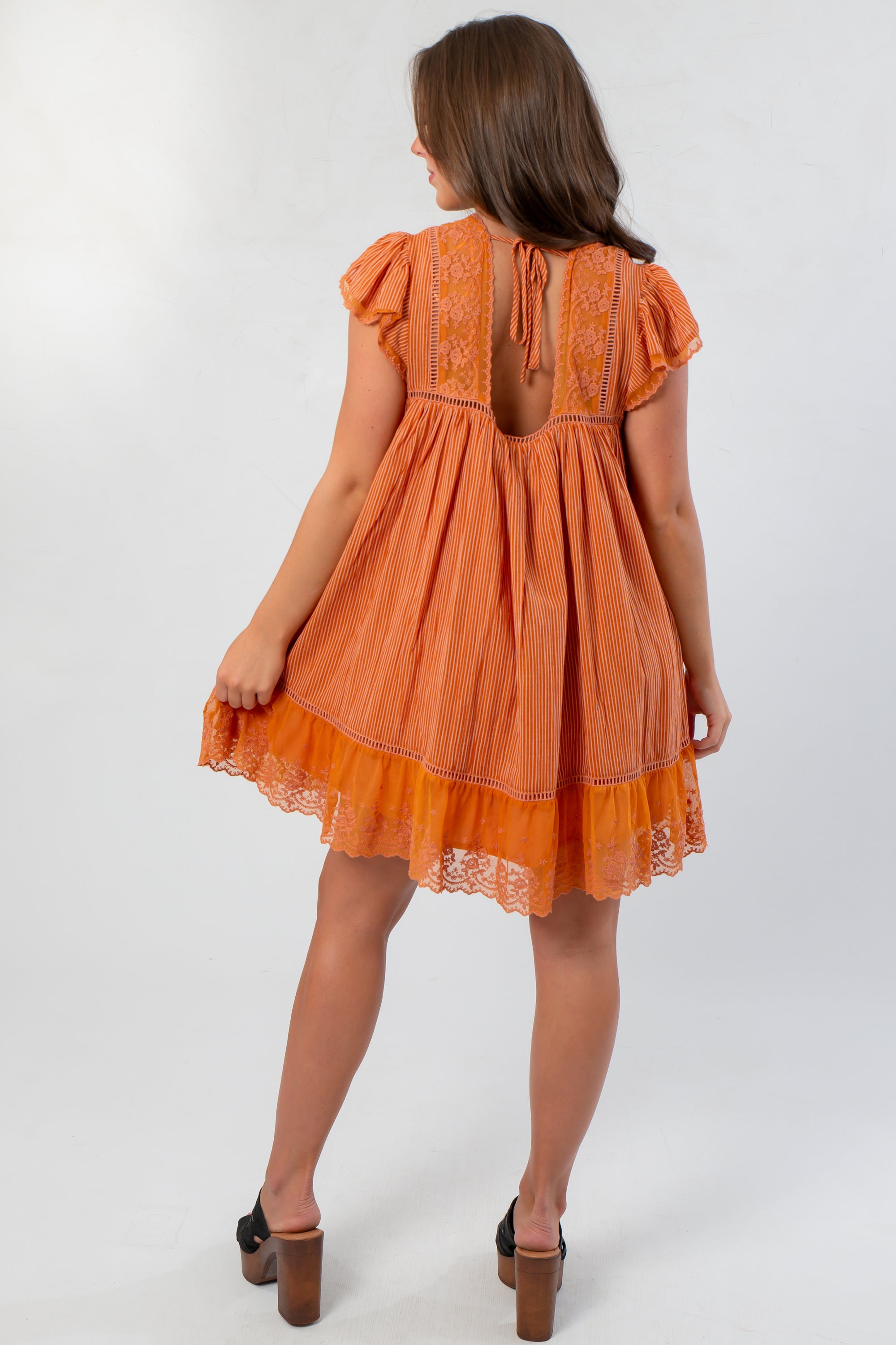 Back view of Amber Romance Lace Babydoll Dress featuring lace paneling and keyhole tie detail for a romantic finish.