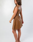 Side profile of Coffee Date Chocolate Faux Leather Mini Dress showing ruched waist detail and smooth faux leather texture.