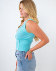 Woman wearing a light blue tank top and denim skirt on a white background