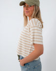 Women in striped knit tee, wearing baseball cap, casual look