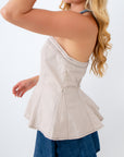 Woman wearing a beige top and denim shorts on a white background