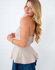 Woman wearing a beige top and denim skirt on a white background