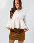 Effortless Icon Ivory Peplum Cardigan – elegant cream peplum sweater with front buttons, styled with a brown suede mini skirt for fall fashion.