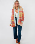 Iris Orange Stripe Open Cardigan – Oversized knit cardigan with multicolor stripes, drop shoulders, and front open design, styled with denim and boots.