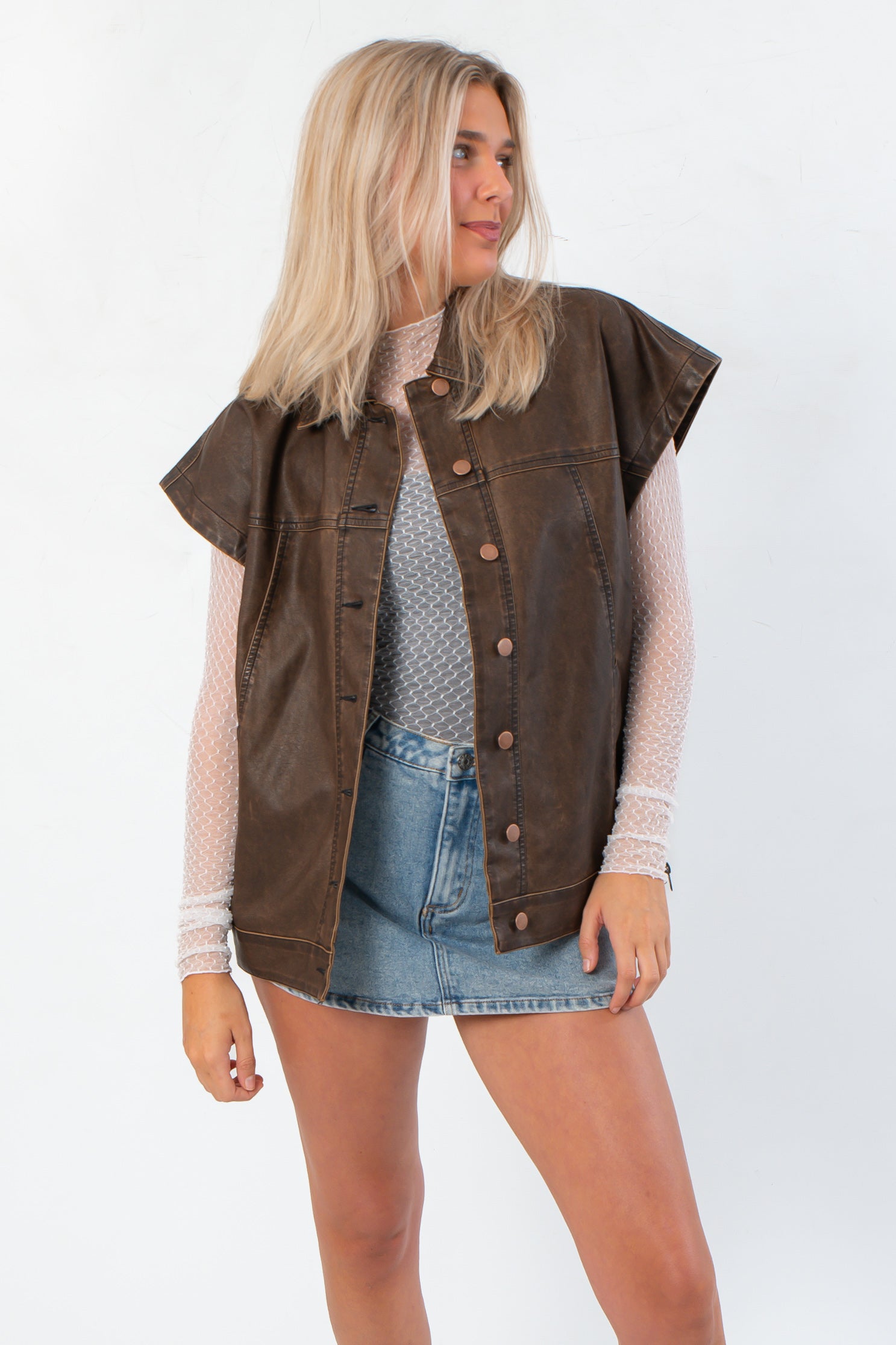 Bittersweet Chocolate Brown Faux Leather Oversized Vest – Modern Style layered over mesh top and denim skirt, perfect for trendy fall outerwear.
