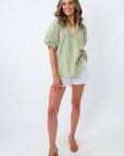 sage green gingham top styled with white shorts and statement necklace