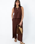 Women wearing Z Supply Chocolate Cherry Scout Linen Pant in relaxed fit, brown linen fabric, paired with beige sandals and jewelry