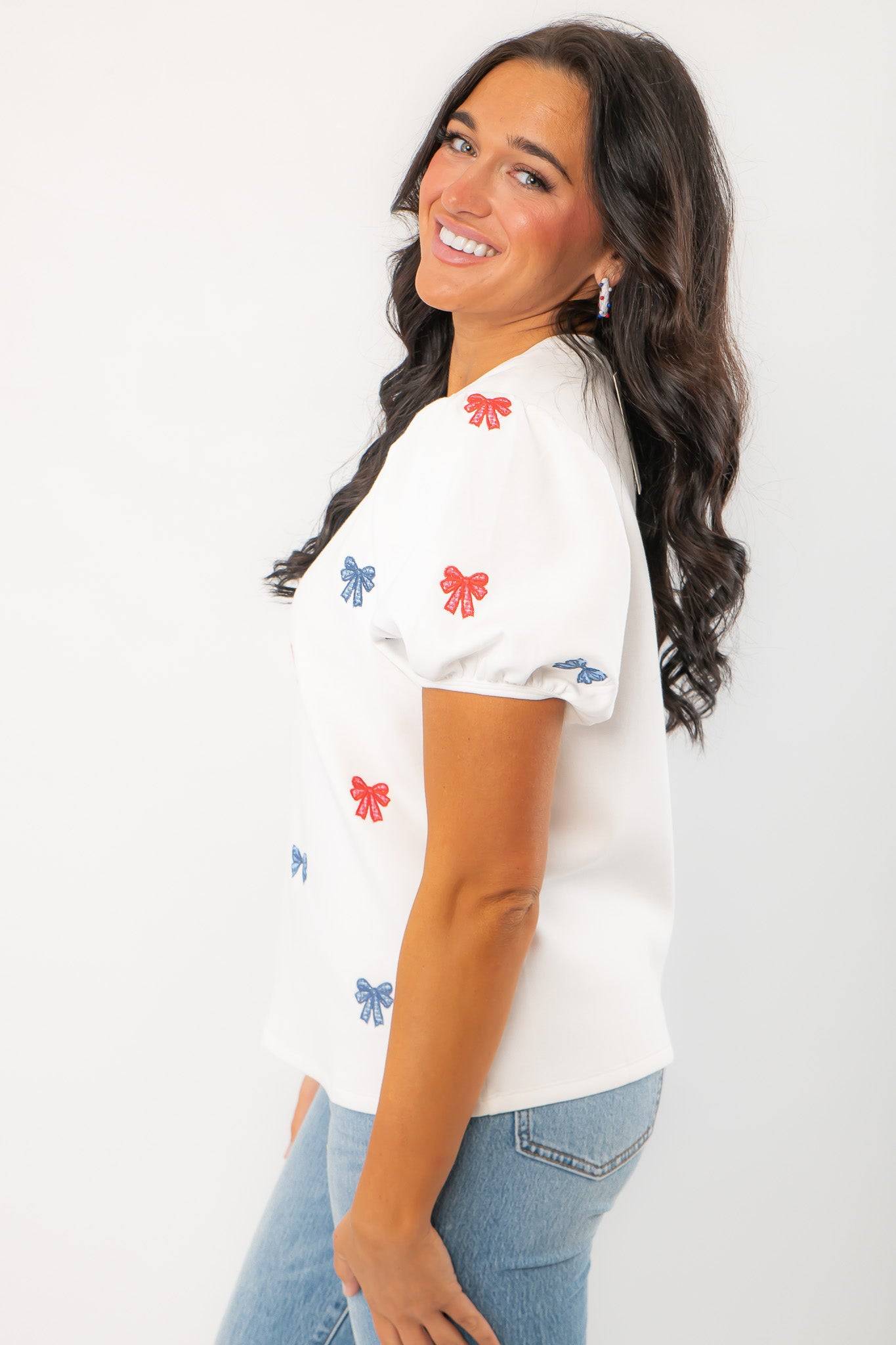 Side profile of THML Red & Blue Bow Embroidery Top with puff sleeves and embroidered bows, perfect for festive summer occasions.