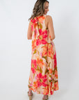 Woman in floral maxi dress with pockets, front view, colorful large flower print, ideal for spring and summer occasions