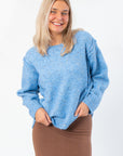 Lorelai Blue Marbled Round Neck Sweater with cozy texture and inverse stitching, styled with a brown skirt for a casual fall look.
