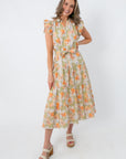 Side view of a woman in a floral midi dress with ruffled sleeves and a tie waist, ideal for casual summer wear