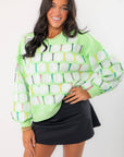 Queen of Sparkles Green Golf Ball & Tee Sweatshirt featuring sequin golf ball and colorful tee pattern, styled with black mini skirt.