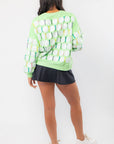 Back view of Queen of Sparkles Green Golf Ball & Tee Sweatshirt showcasing full sequin golf ball and tee pattern on soft green fabric.