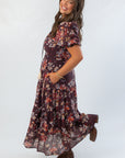 Side view of THML Burgundy Printed Puff Sleeve Tiered Maxi Dress showing flowy silhouette and floral print, perfect for autumn fashion.
